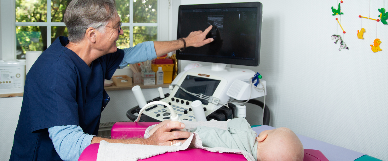 Dr. Kästner führt eine Hüftsonographie im Rahmen der U3-Vorsorgeuntersuchung durch